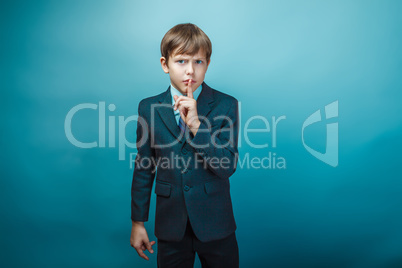European appearance teenager boy in a business suit put his fing