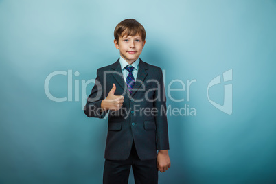 European appearance teenager boy in a business suit shows a sign