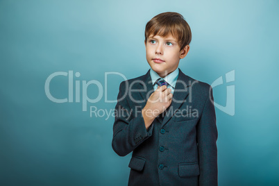 European appearance teenager boy in a business suit straightens