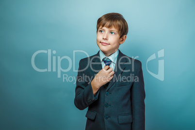 European appearance teenager boy in a business suit straightens