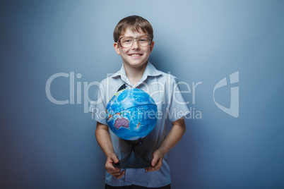 European appearance teenager boy with glasses holding a globe on