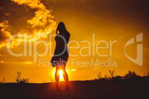 European appearance young woman standing at sunset looking at th
