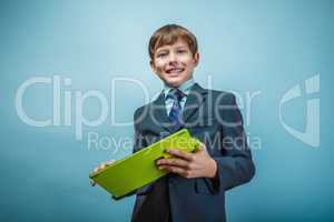 Teen boy businessman European appearance in a business suit hold
