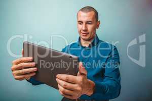 a man of European appearance thirty years looking at tablet smil