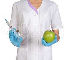 Medical worker holding a syringe injection and green apples