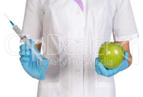 Medical worker holding a syringe injection and green apples