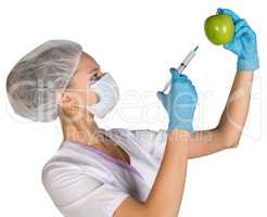 Woman holding an apple and is injected with a syringe. Genetically modified foods