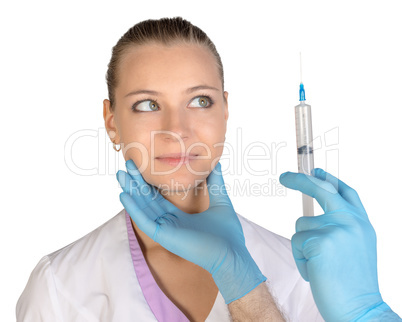 Surprised young woman looking at needle of syringe with an injection Botox