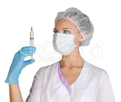 Doctor a masked holds before him syringe in hand