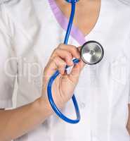 Woman doctor in lab coat holding stethoscope