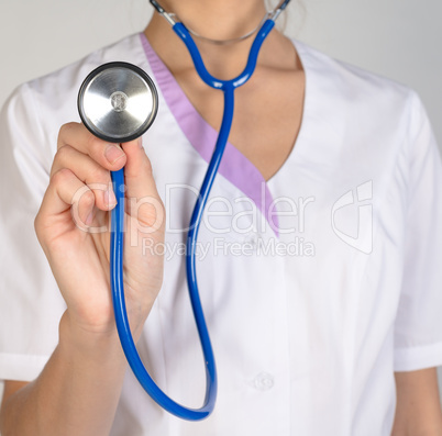 Woman doctor in lab coat holding stethoscope