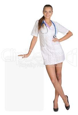 Young woman doctor standing leaning hand on an empty billboard