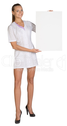 Woman doctor showing blank billboard standing on a white background