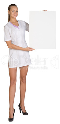Woman doctor showing blank billboard standing on a white background