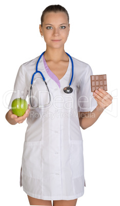 Woman doctor holding an apple and chocolate symbolize proper nutrition, diet