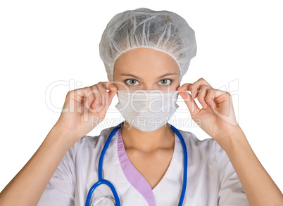 Young woman doctor in cap and face mask on white background