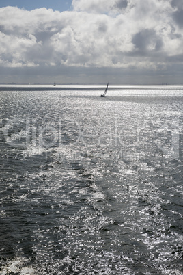 Sun over the Wadden Sea with sailing boat.