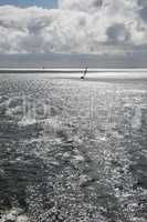 Sun over the Wadden Sea with sailing boat.