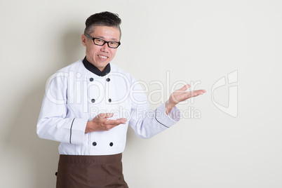 Mature Asian Chinese chef showing something