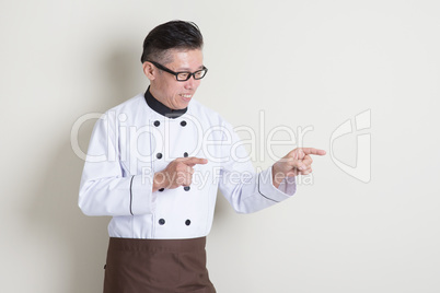 Mature Asian Chinese chef pointing