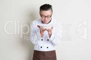 Mature Asian Chinese chef smelling aroma