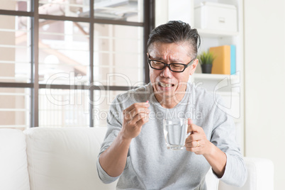 Mature Asian Chinese man eating medicine