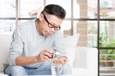 Asian man eating medicine