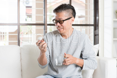 Asian man eating vitamins