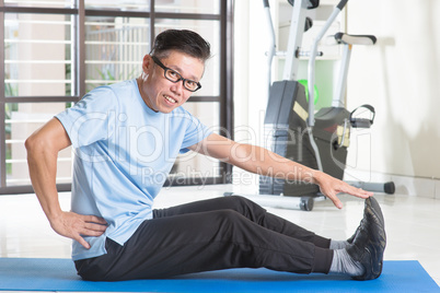 Mature Asian man exercising at gym