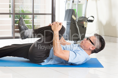 Mature Asian man exercise at gym