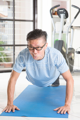 Mature Asian man pushup at gym