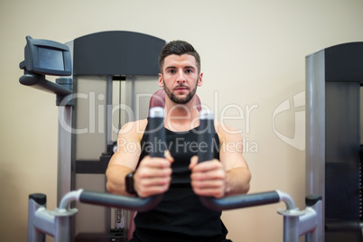 Focused man working out on the weights machine