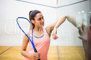 Smiling woman holding a squash racket