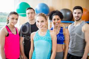 Fitness class smiling at camera in studio