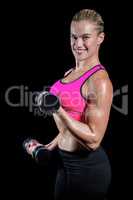 Muscular woman lifting heavy dumbbells