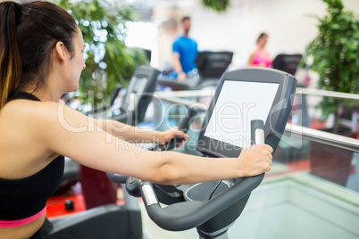 Woman on an exercise bike looking at the tv screen