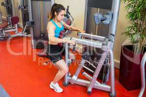 Focused woman using weights machine