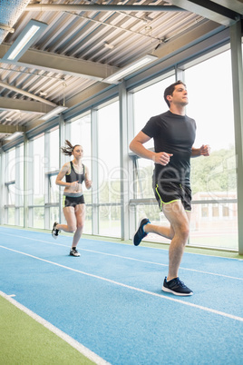 Couple running on the indoor track