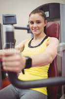 Fit woman using weights machine