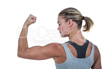 Rear view of muscular woman flexing muscles