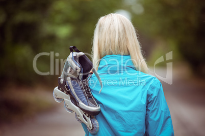 Happy blonde holding inline skates