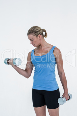 Muscular woman exercising with dumbbells Muscular woman exercising with dumbbells