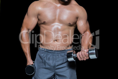 Mid section of a bodybuilder with dumbbells