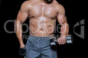 Mid section of a bodybuilder with dumbbells