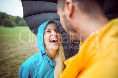 Happy couple on a hike under umbrella