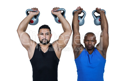 Strong friends lifting kettlebells together