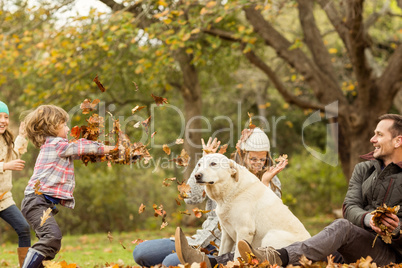 Young family with a dog in leaves