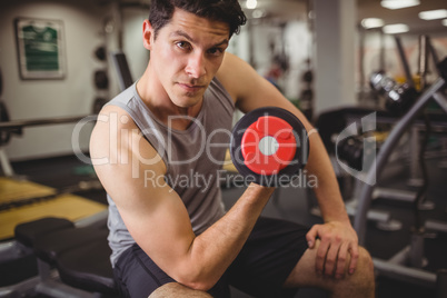 Fit man lifting heavy black dumbbell