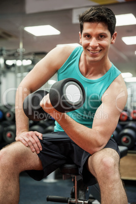 Smiling man lifting dumbbell weight