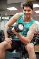 Smiling man lifting dumbbell weight